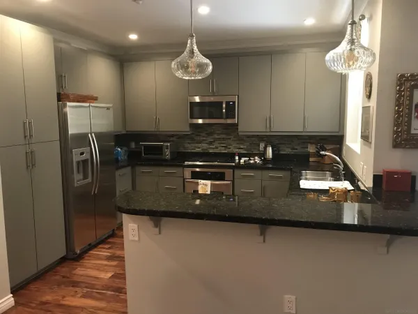 a kitchen with stainless steel appliances granite countertop a sink a stove and a refrigerator