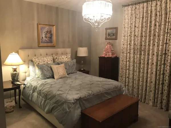 a bedroom with a bed and a chandelier