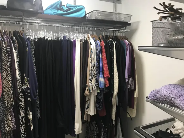 a view of walk in closet with clothes and shoes