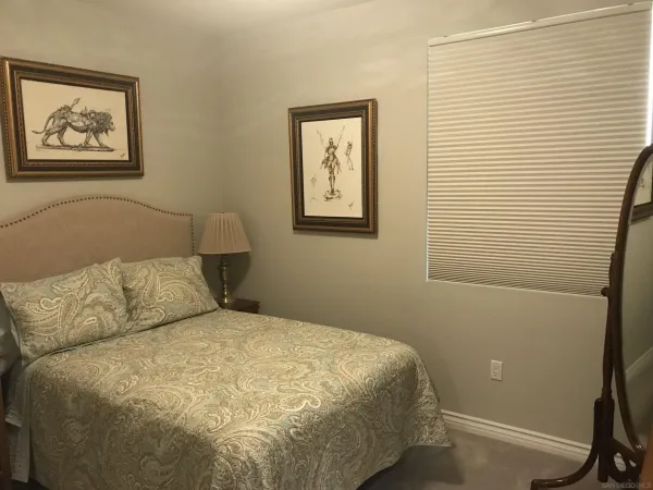 a bed room with a bed and painting on the wall