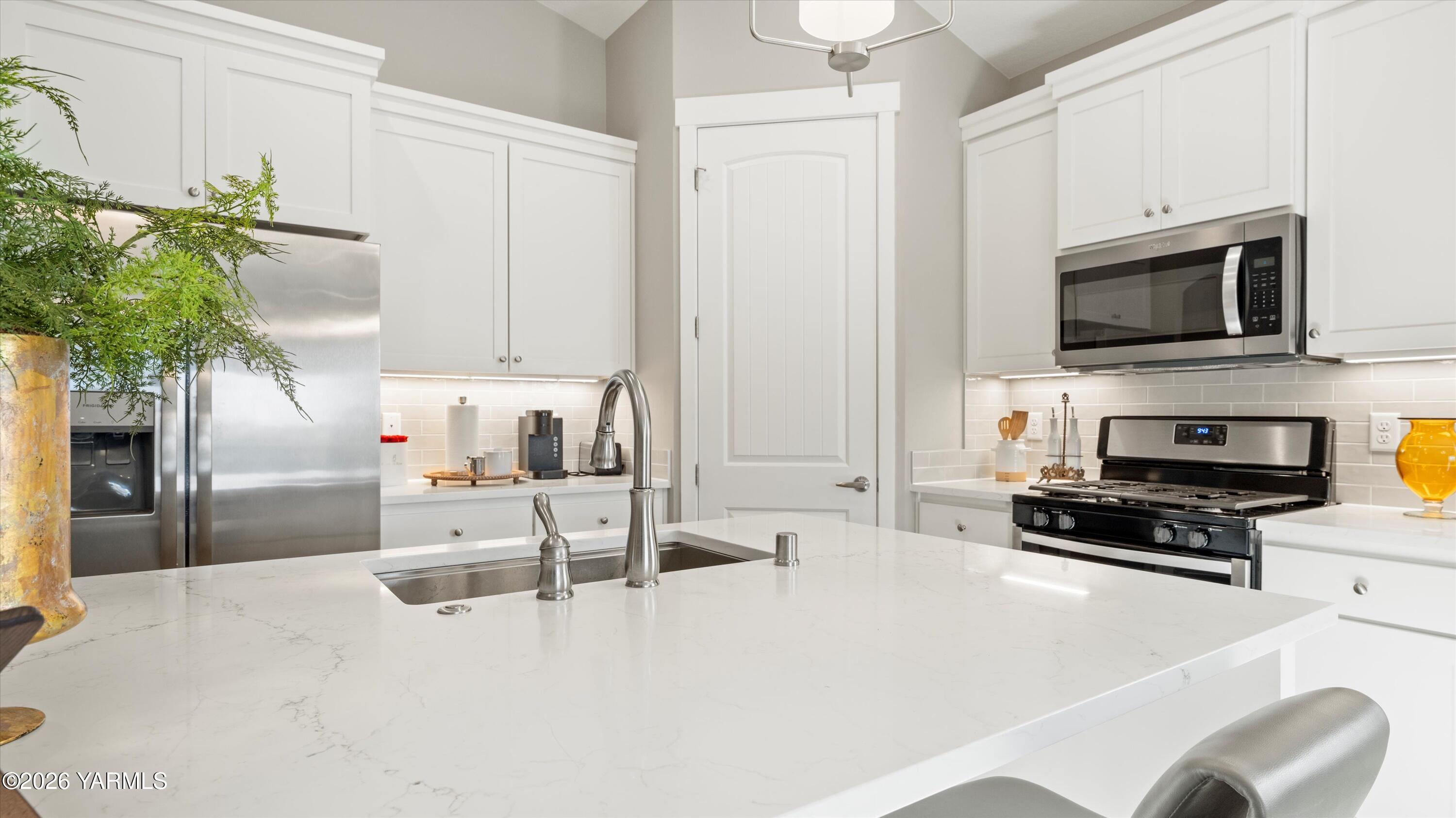 208 Bratton Street Prosser, WA 99350 - Photo 11 of 36 a kitchen with stainless steel appliances a stove a microwave a sink a refrigerator and a white cabinets