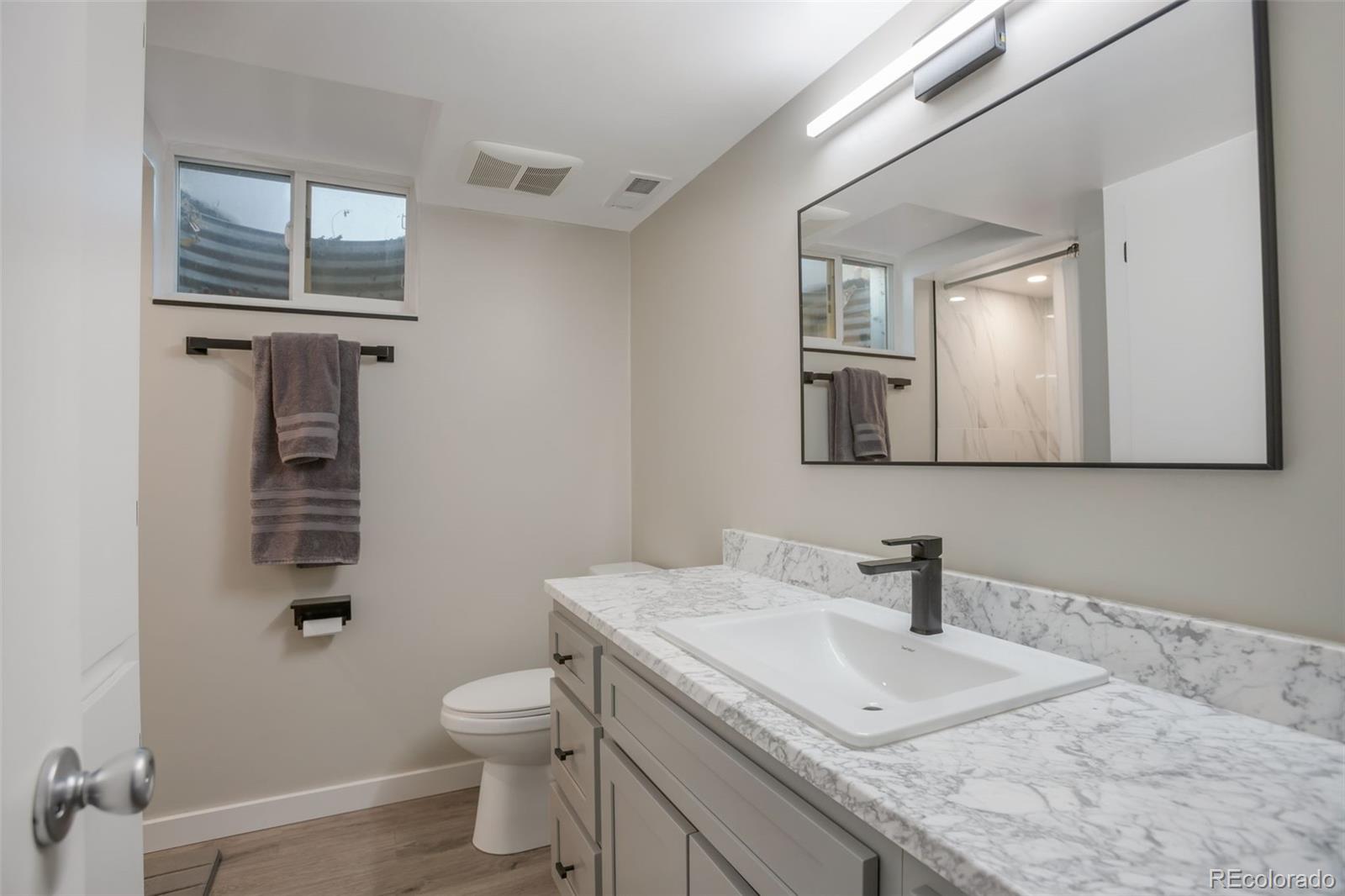 6221 South Logan Court Centennial, CO 80121 - Photo 20 of 30 a bathroom with a granite countertop toilet sink and mirror