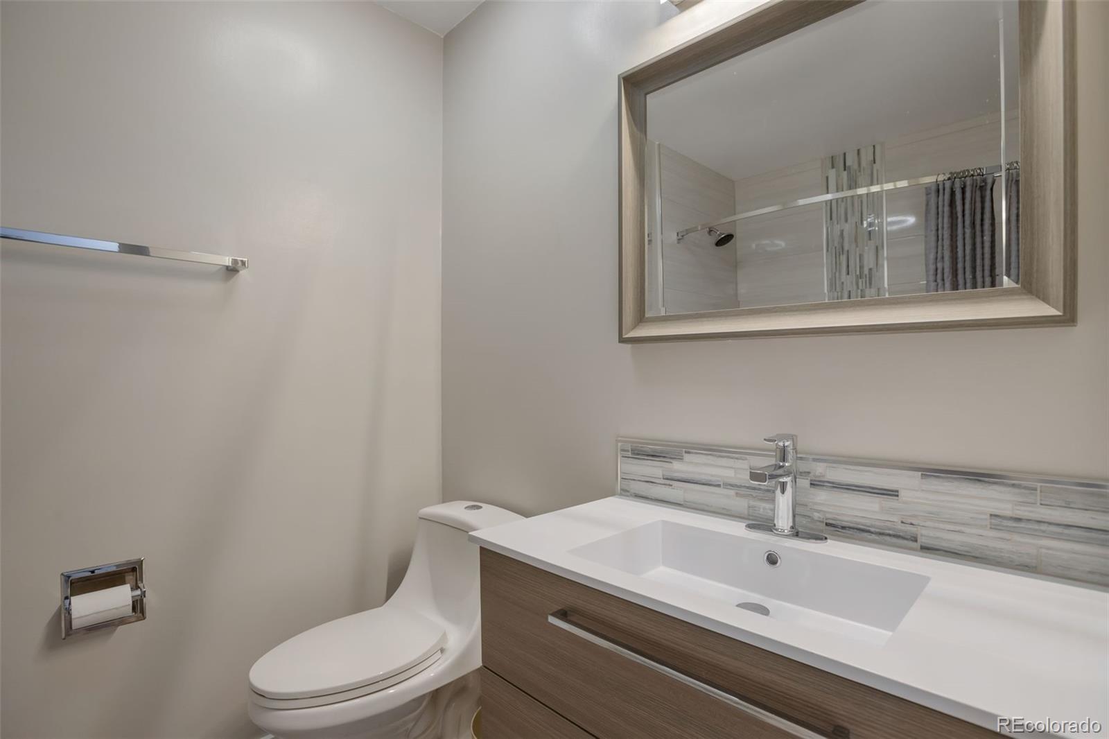 6221 South Logan Court Centennial, CO 80121 - Photo 23 of 30 a bathroom with a toilet a sink and mirror
