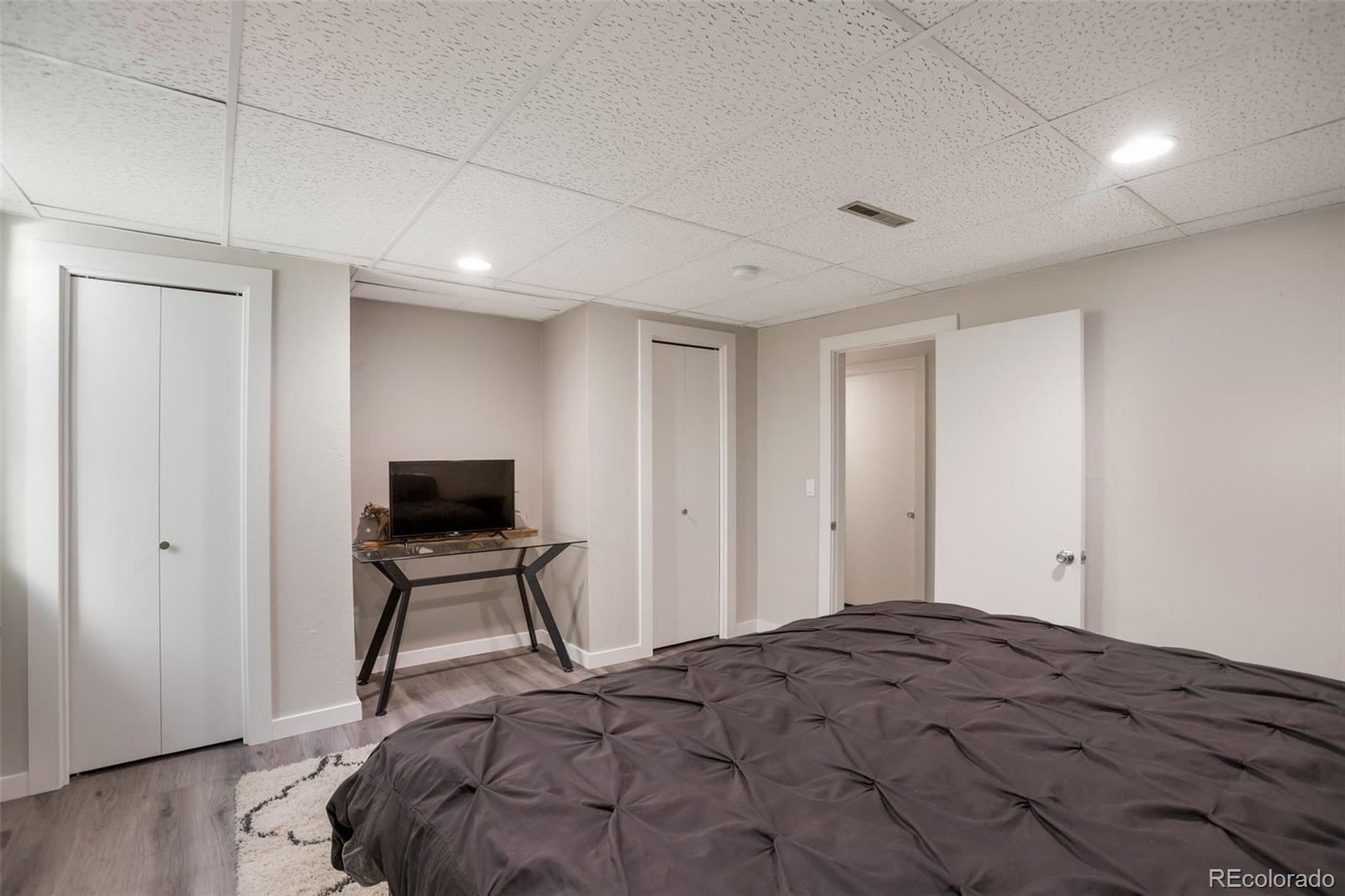 6221 South Logan Court Centennial, CO 80121 - Photo 27 of 30 a bedroom with a bed and a tv on table