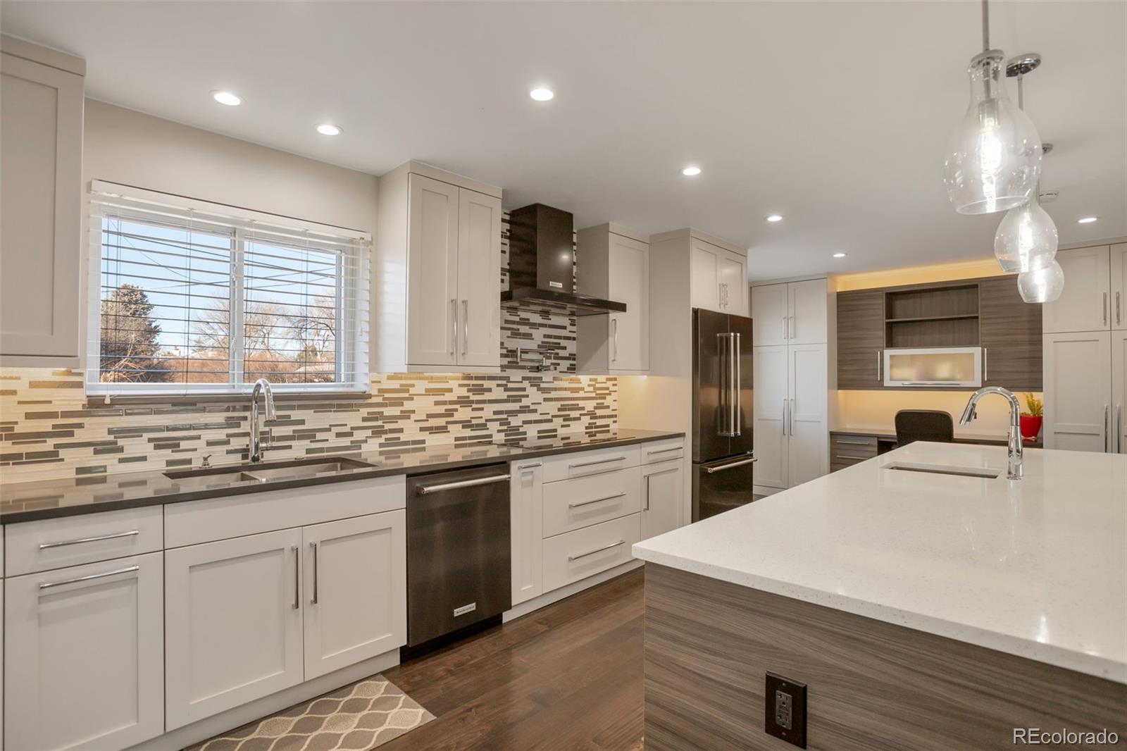 6221 South Logan Court Centennial, CO 80121 - Photo 7 of 30 a kitchen with stainless steel appliances kitchen island granite countertop a sink and cabinets