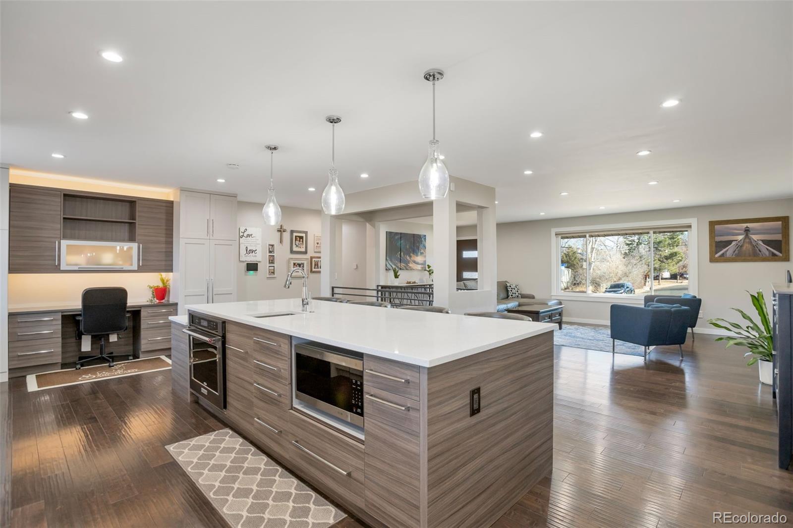 6221 South Logan Court Centennial, CO 80121 - Photo 8 of 30 a large white kitchen with a stove a sink a refrigerator and a dining table with wooden floor