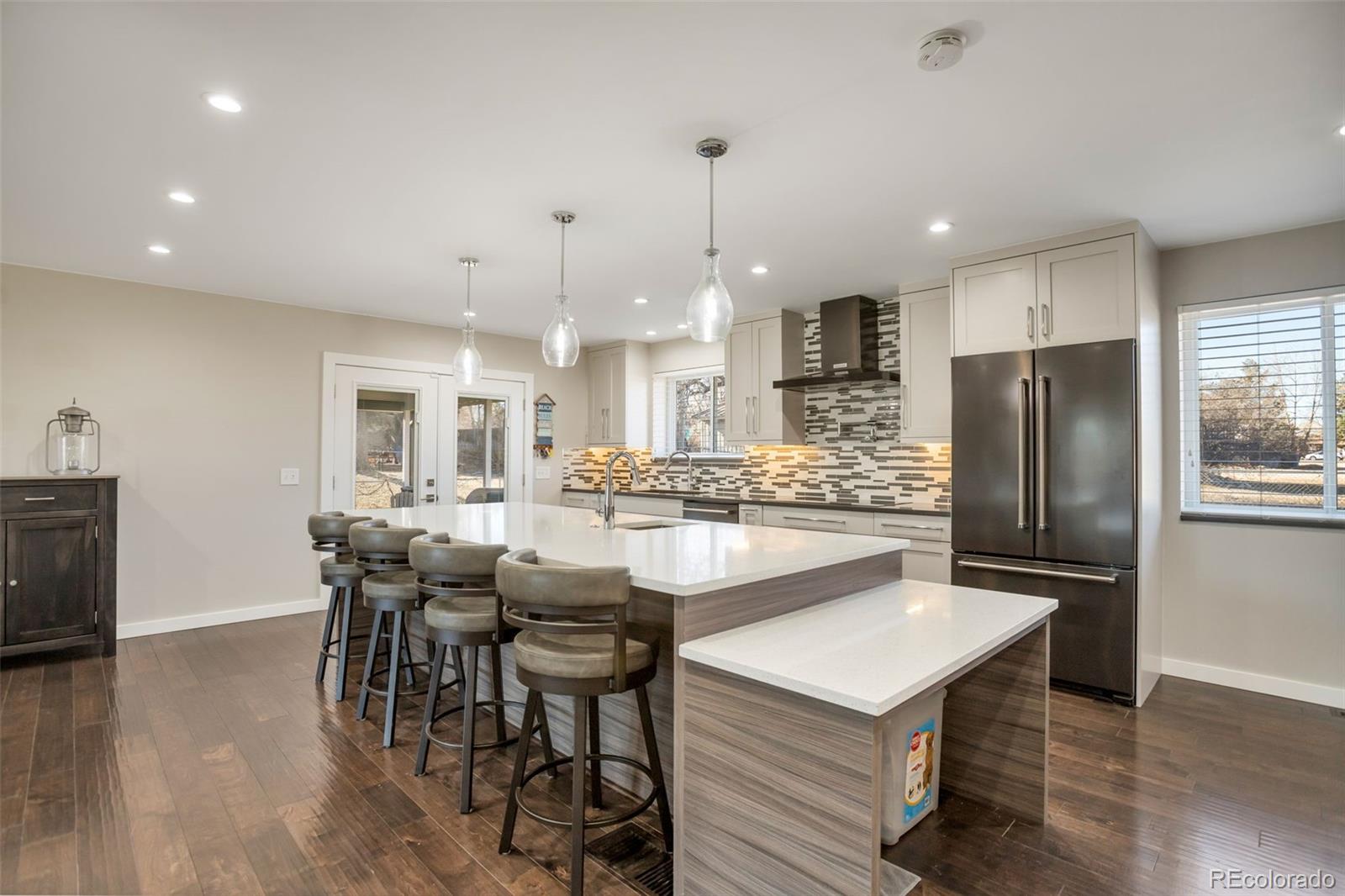 6221 South Logan Court Centennial, CO 80121 - Photo 9 of 30 a kitchen with stainless steel appliances a dining table chairs stove and refrigerator