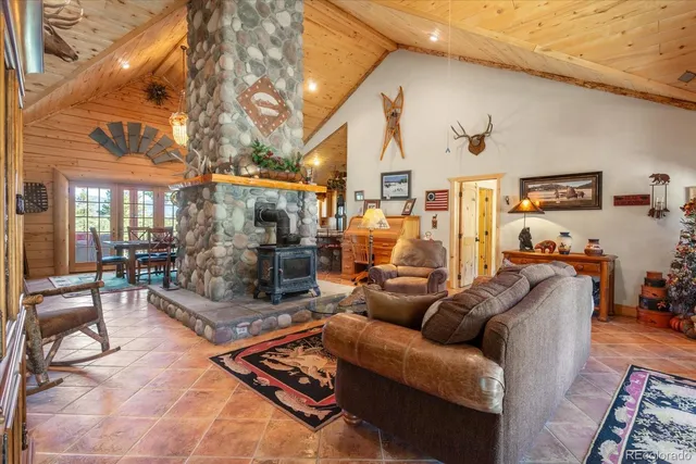 a living room with furniture a large window and a fireplace