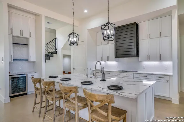 a kitchen with kitchen island granite countertop a sink a center island a stove and a cabinets