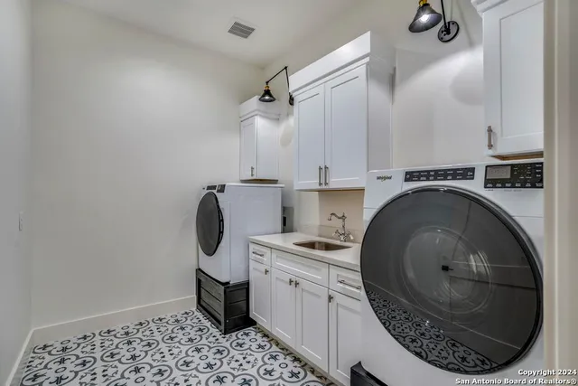 a utility room with sink dryer and washer