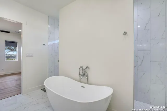 a bathroom with a white tub and shower
