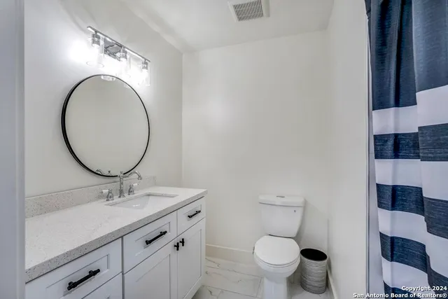 a bathroom with a toilet a sink and a mirror