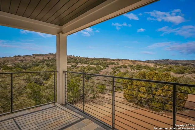 a view of a balcony with a yard