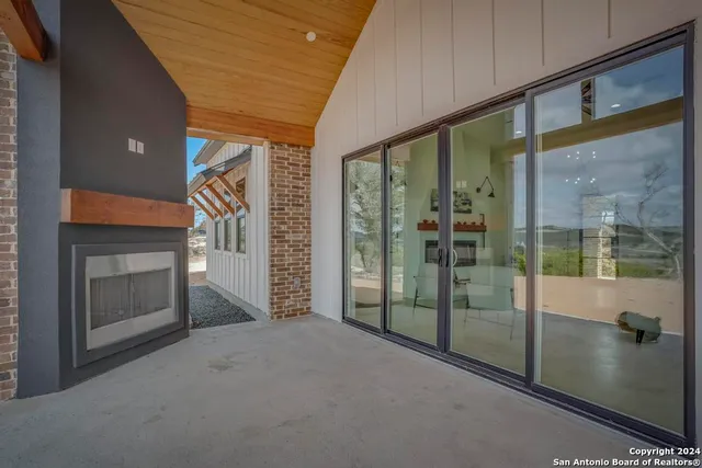 a view of empty room with floor to ceiling window and fireplace