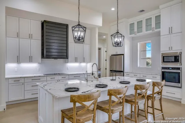 a kitchen with a dining table chairs and microwave