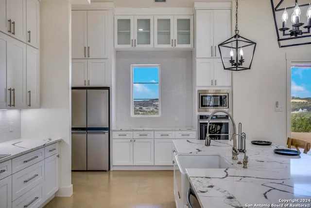 a kitchen with stainless steel appliances granite countertop a refrigerator a stove a sink and dishwasher