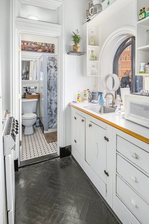 1 Otis Place Boston, MA 02108 - Photo 21 of 22 a spacious bathroom with a shower a sink and a mirror