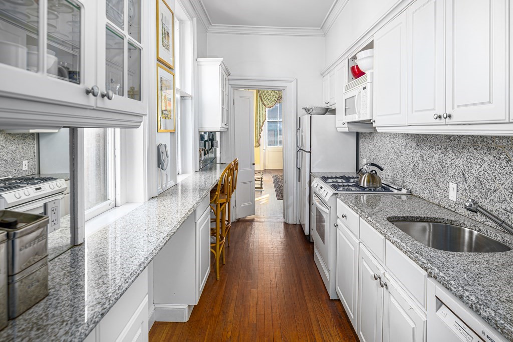 1 Otis Place Boston, MA 02108 - Photo 6 of 22 a kitchen with stainless steel appliances granite countertop lots of counter top space and wooden floor