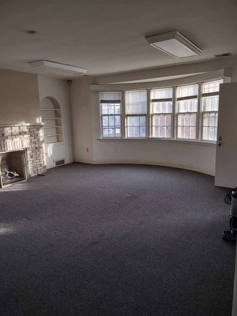 417 Taylor Street Joliet, IL 60435 - Photo 1 of 11 a view of an empty room with a fireplace and a window