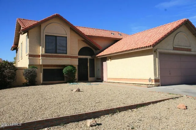 a view of house with wooden fence and a garage