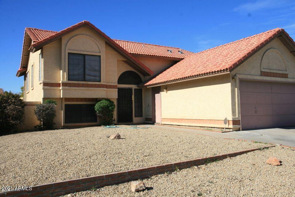 a view of house with wooden fence and a garage