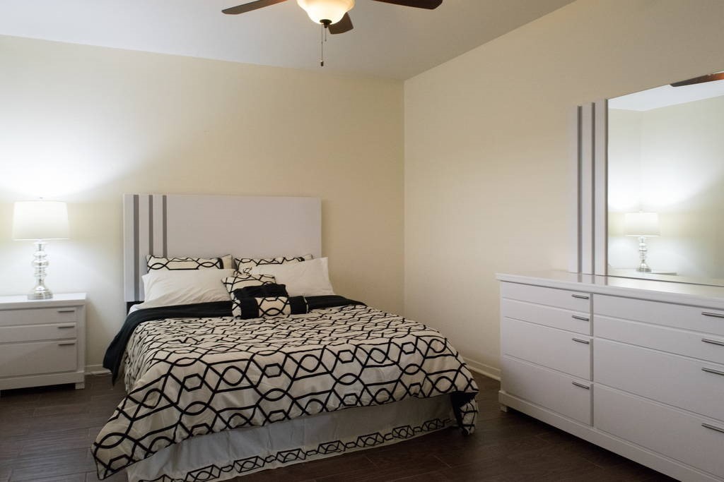 3942 West Alabama Street, Unit 5 Houston, TX 77027 - Photo 5 of 28 a bedroom with a large bed and a chandelier