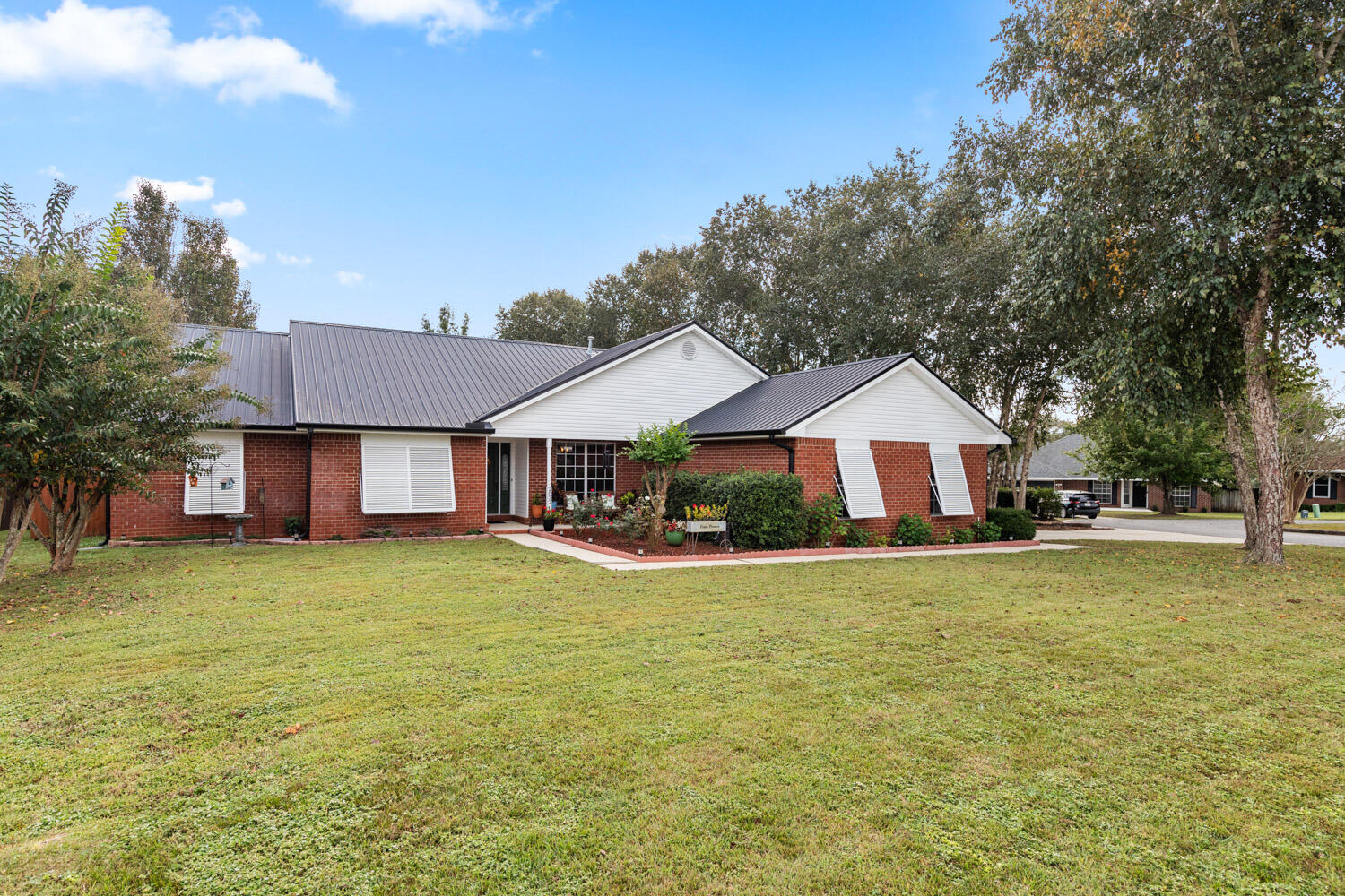 2852 Atoka Trail Crestview, FL 32539 - Photo 2 of 45 a front view of a house with a garden and trees