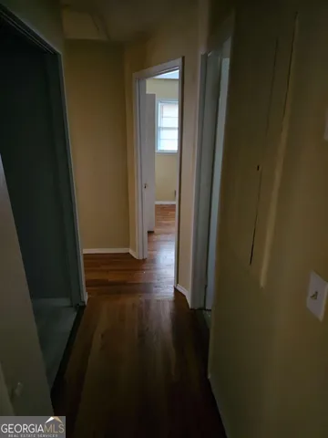 a view of a hallway with wooden floor