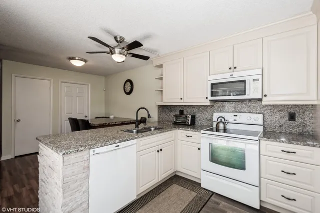 a kitchen with a sink a stove and cabinets