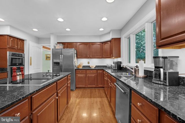 a kitchen with stainless steel appliances granite countertop sink stove top oven and cabinets