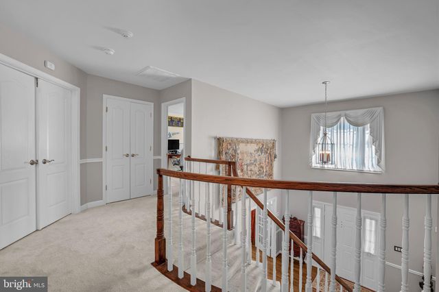 a view of staircase with railing and white walls
