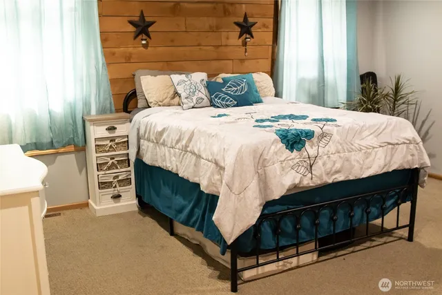 a bed sitting in a bedroom next to a window with a dresser