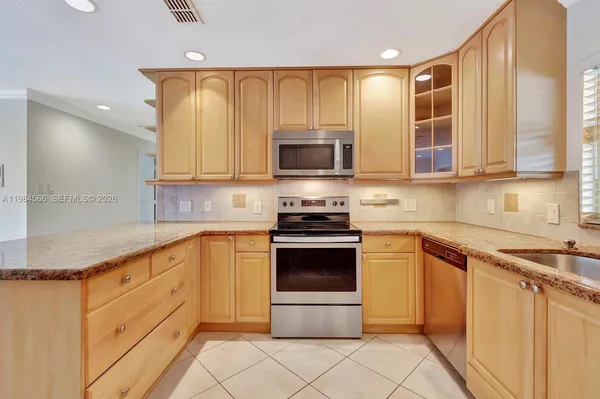 a kitchen with stainless steel appliances a stove a sink and a microwave