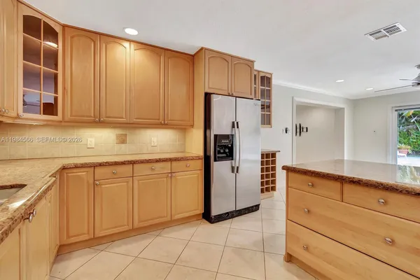 a kitchen with granite countertop cabinets and refrigerator