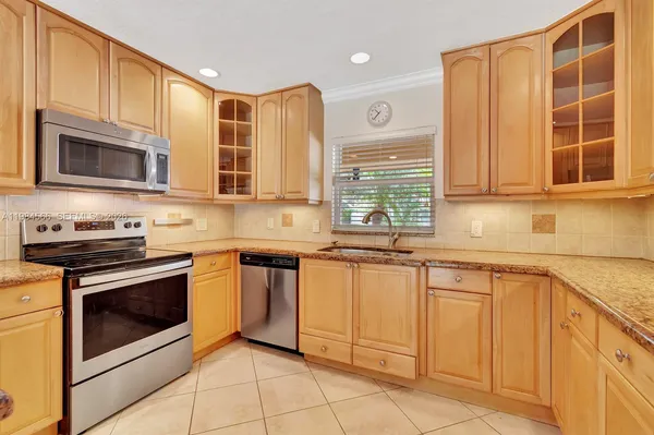 a kitchen with stainless steel appliances granite countertop a stove microwave and cabinets
