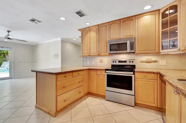 a kitchen with stainless steel appliances granite countertop a stove a microwave and a sink