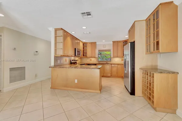 a kitchen with cabinets and a refrigerator