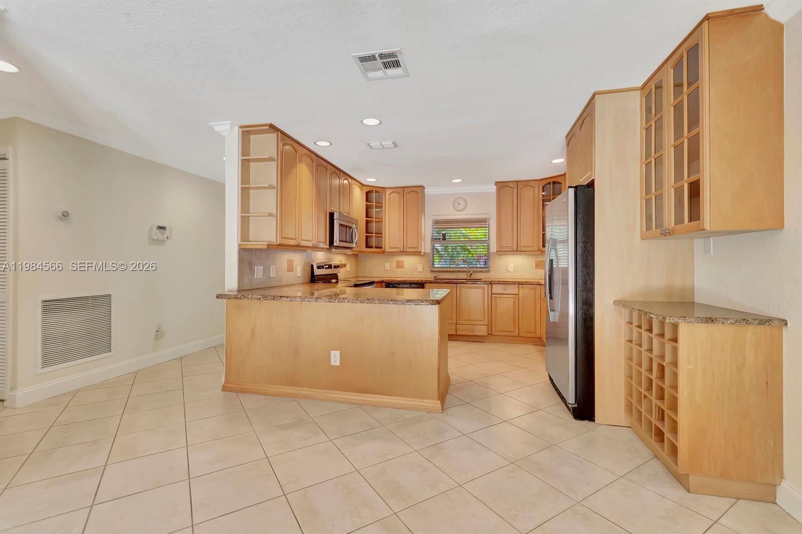 11 Forest Hills Lane Boca Raton, FL 33431 - Photo 15 of 24 a kitchen with cabinets and a refrigerator