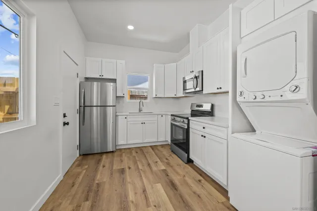 a kitchen with a refrigerator a sink and a stove top oven