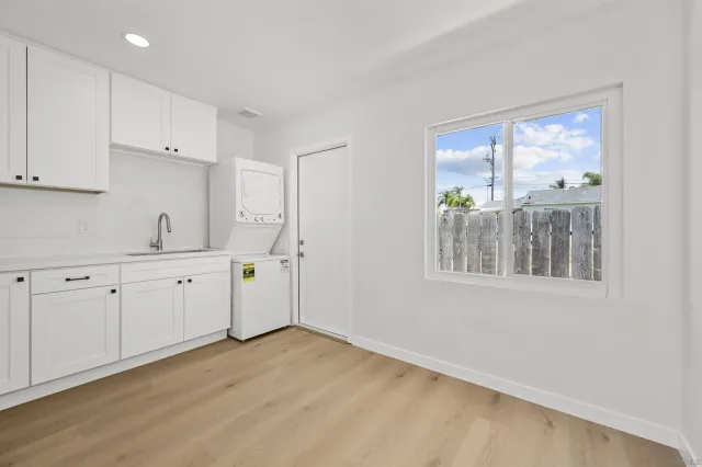 a room with white cabinets and wooden floors