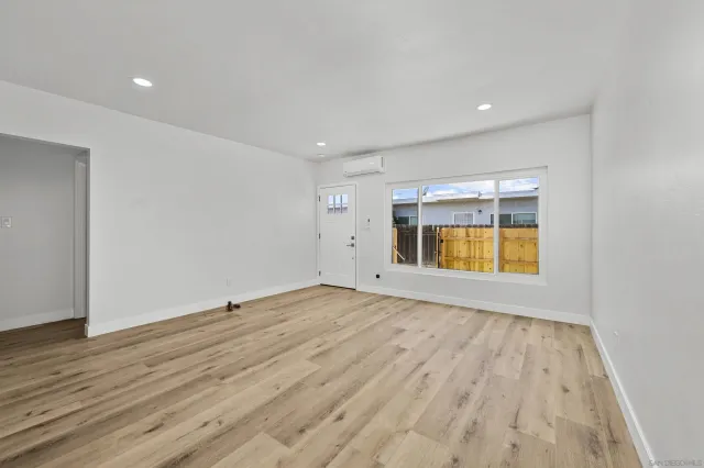 an empty room with wooden floor and glass door