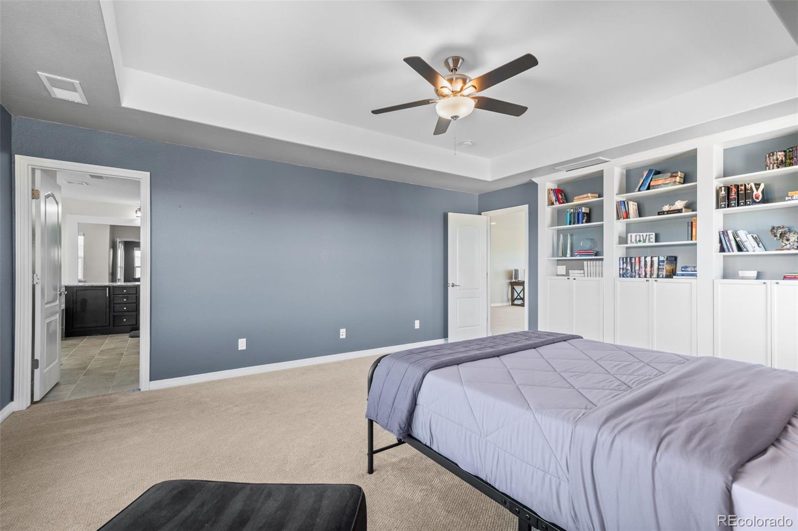 2910 El Nido Way Castle Rock, CO 80108 - Photo 21 of 50 a bedroom with a large bed and a chandelier