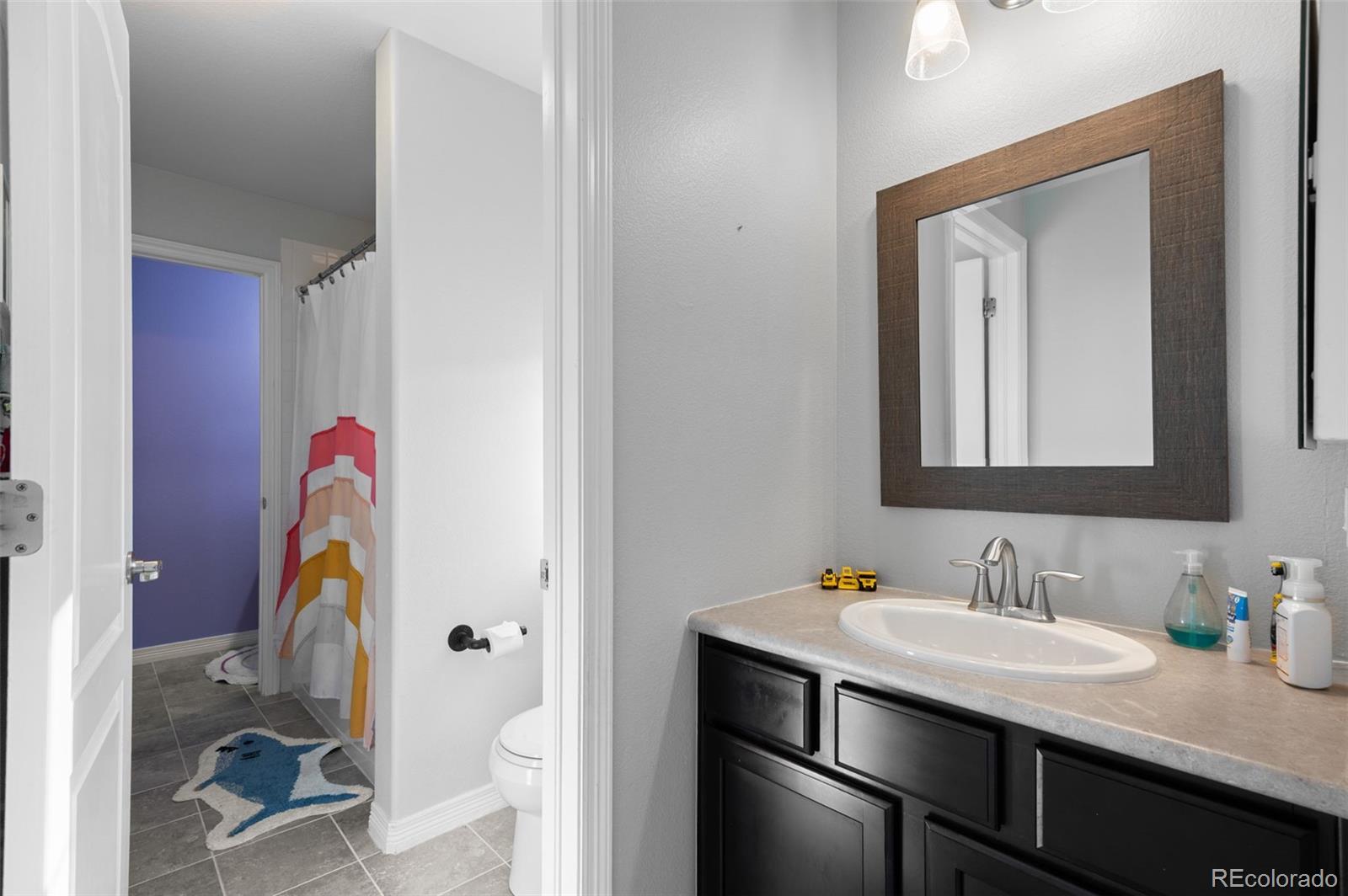 2910 El Nido Way Castle Rock, CO 80108 - Photo 29 of 50 a en suite bathroom with a granite countertop sink and a mirror