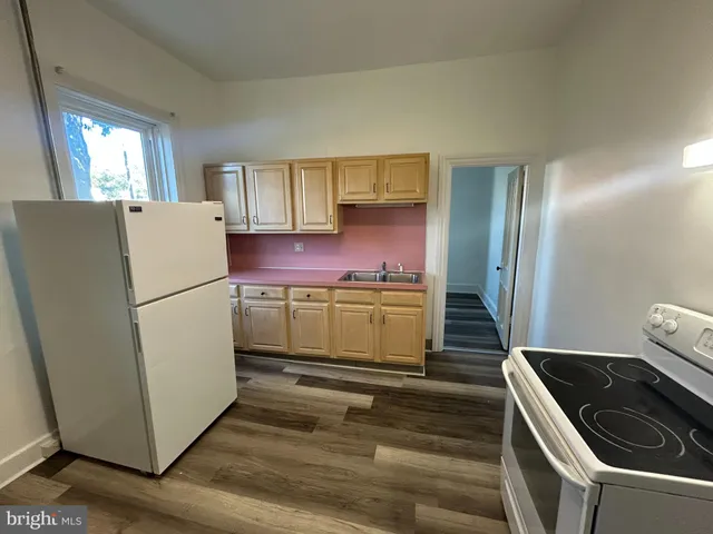 a kitchen with a refrigerator sink and cabinets