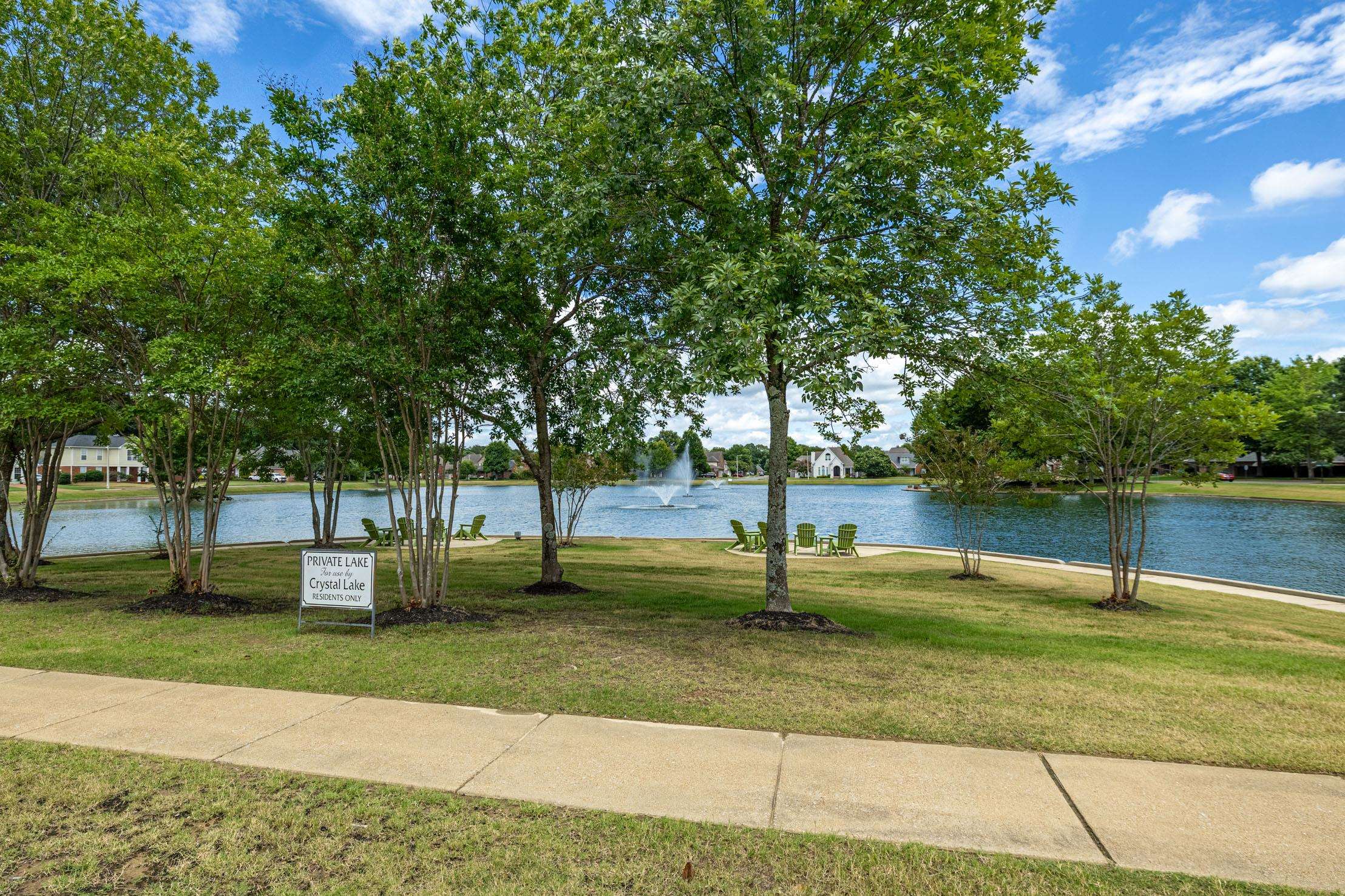 96 Berryfield Cove Collierville, TN 38017 - Photo 35 of 39 Lakeside property featuring a tranquil water fountain, mature trees, and a paved walkway