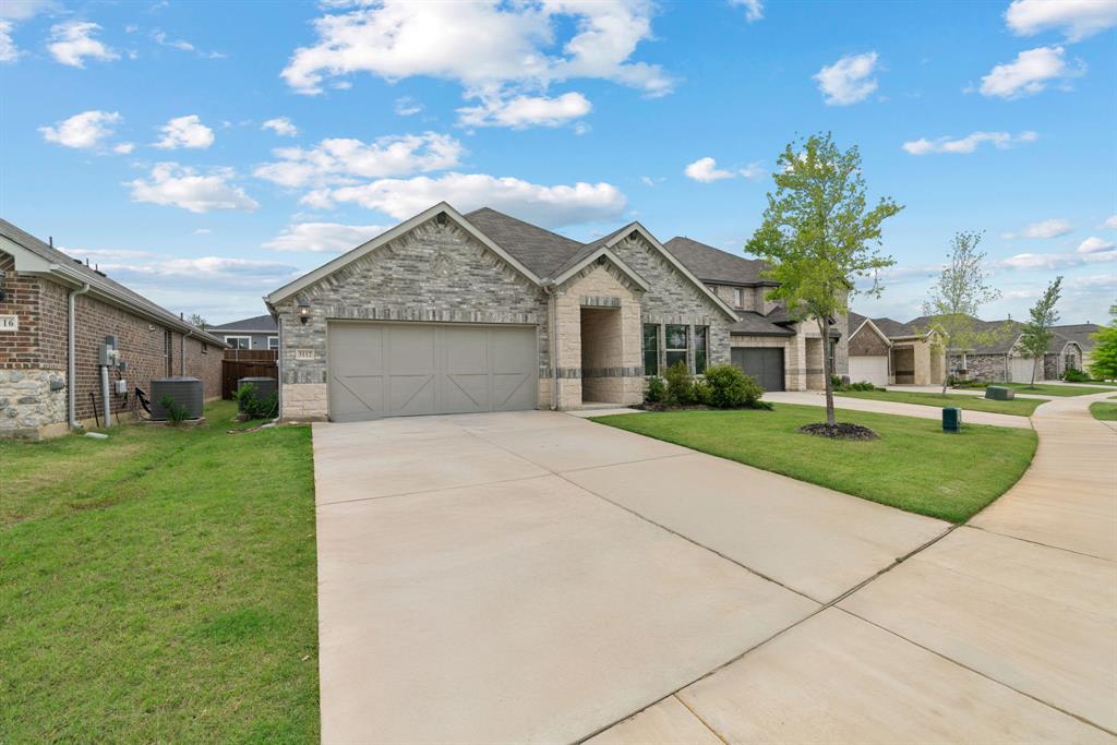 3112 Kingsgarden Road Denton, TX 76207 - Photo 3 of 38 Stone and brick facade home featuring a two-car garage, concrete driveway, and a landscaped front yard with a young tree