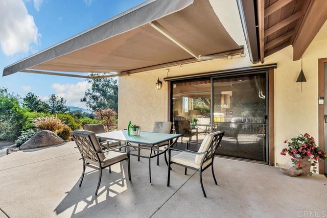 a view of an outdoor dining space with a table and chairs