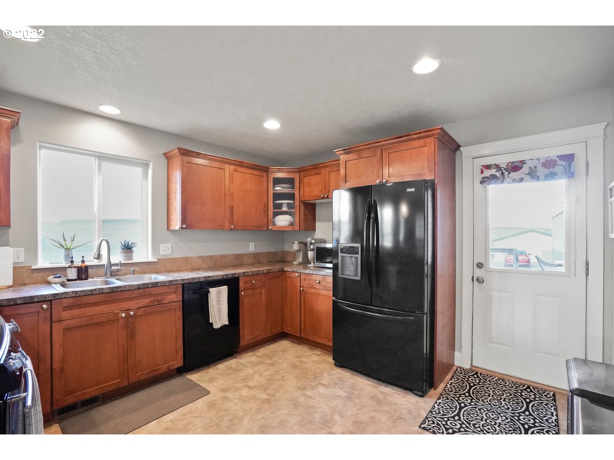 1370 Childers Road Arlington, OR 97812 - Photo 21 of 31 a kitchen with stainless steel appliances granite countertop a refrigerator a sink dishwasher a stove with wooden cabinets