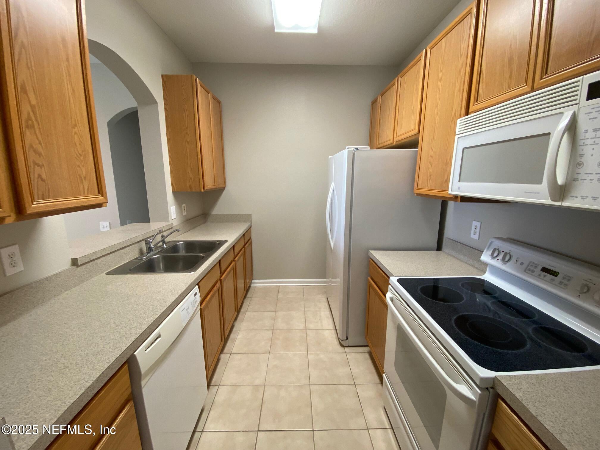 7990 Baymeadows Road, Unit 929 Jacksonville, FL 32256 - Photo 11 of 26 a kitchen that has a sink and a stove