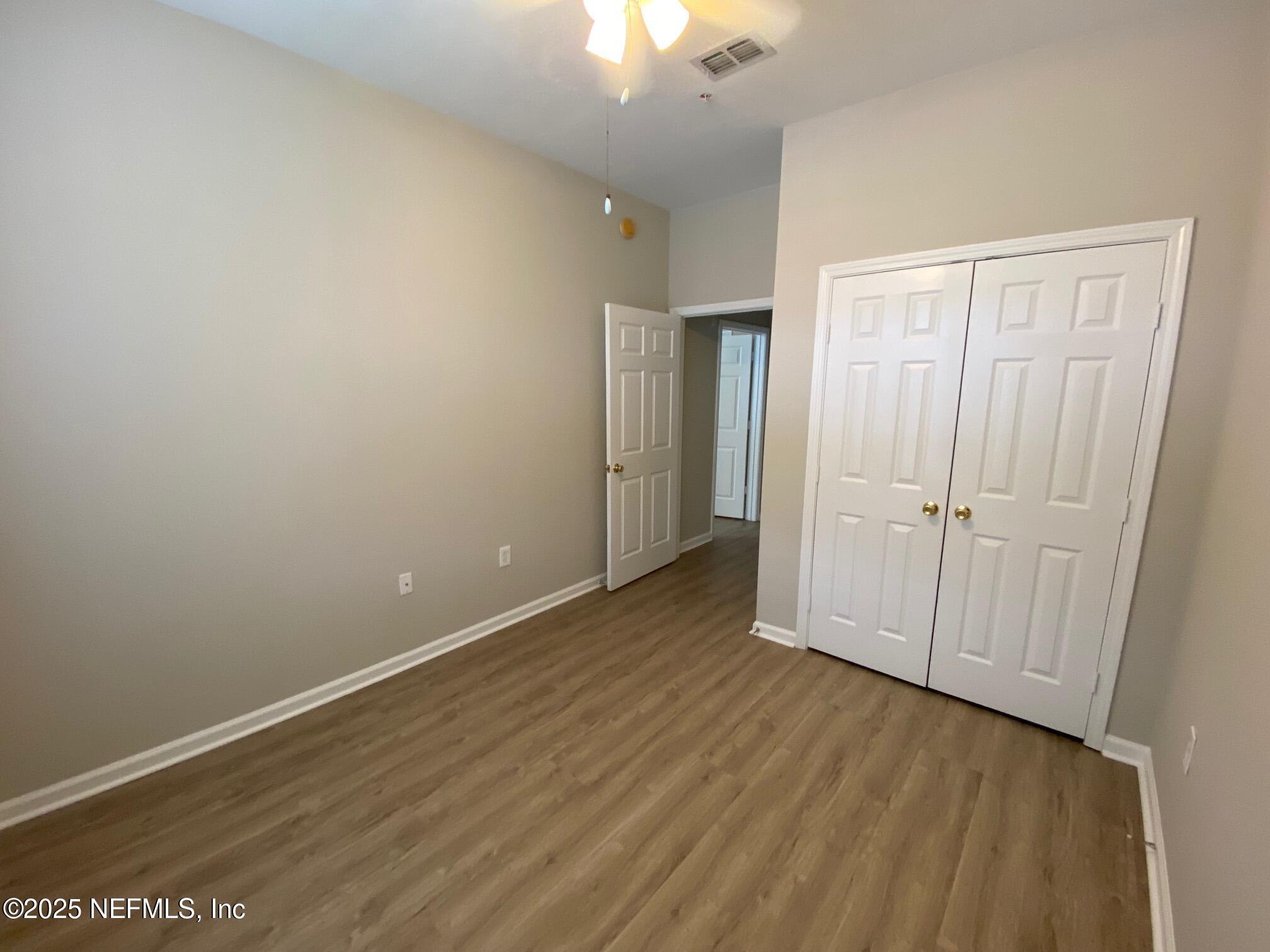 7990 Baymeadows Road, Unit 929 Jacksonville, FL 32256 - Photo 12 of 26 an empty room with wooden floor and a ceiling fan